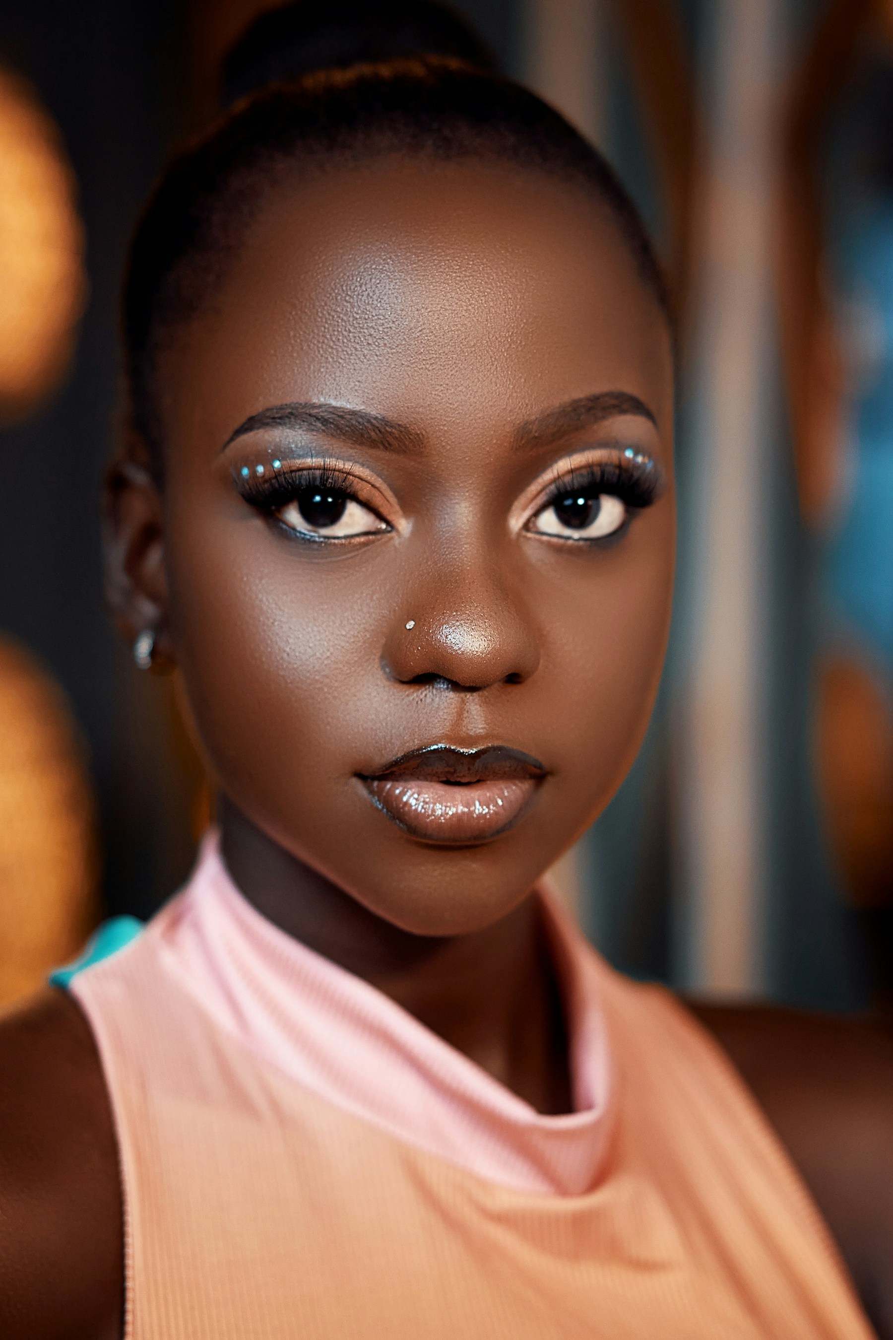 An expressive beauty portrait featuring elaborate eye makeup, glossy lips and decorative blue dots