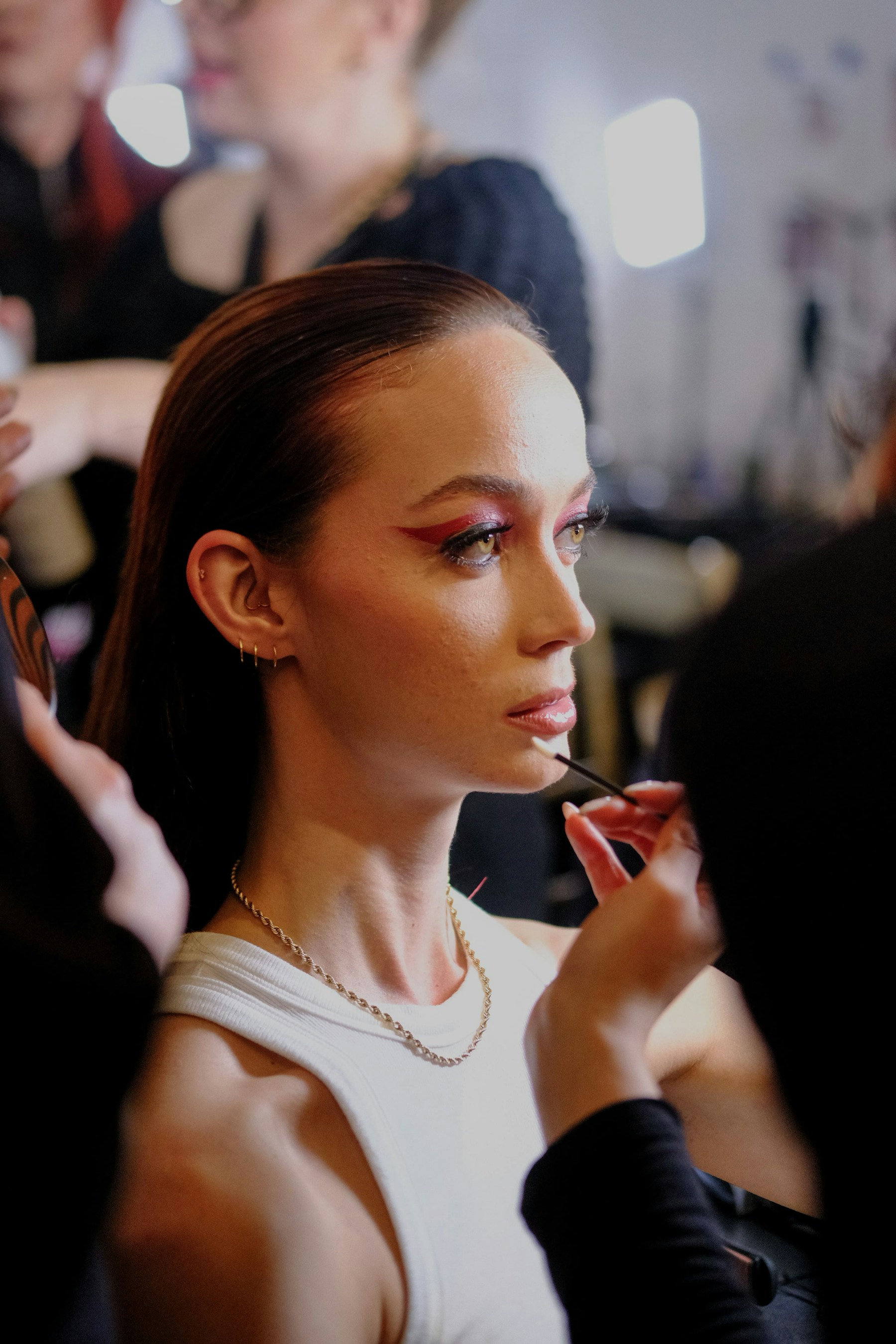 A professional makeup artist preparing a model backstage at New York Fashion Week